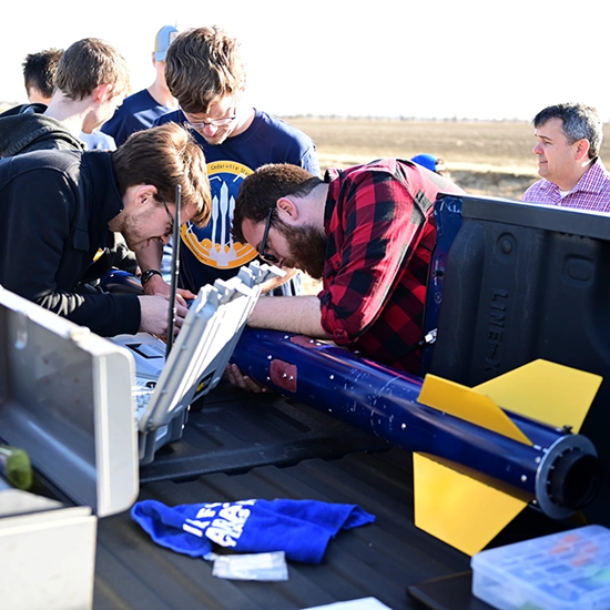 Students preparing a large rocket for launch.