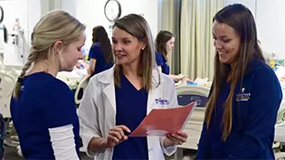 Female nurses reviewing a patient chart.