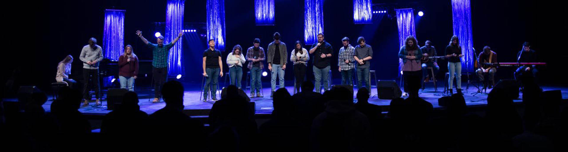 Several students worshipping on the chapel stage