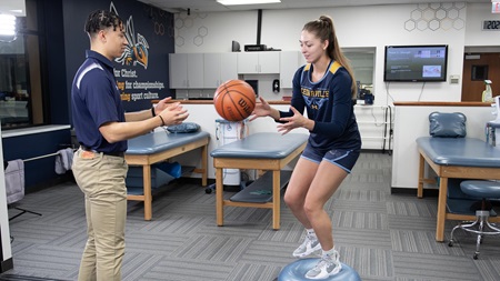 athletic training student rehabbing student athlete in training room