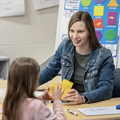Female teacher using flashcards to educate a young child.