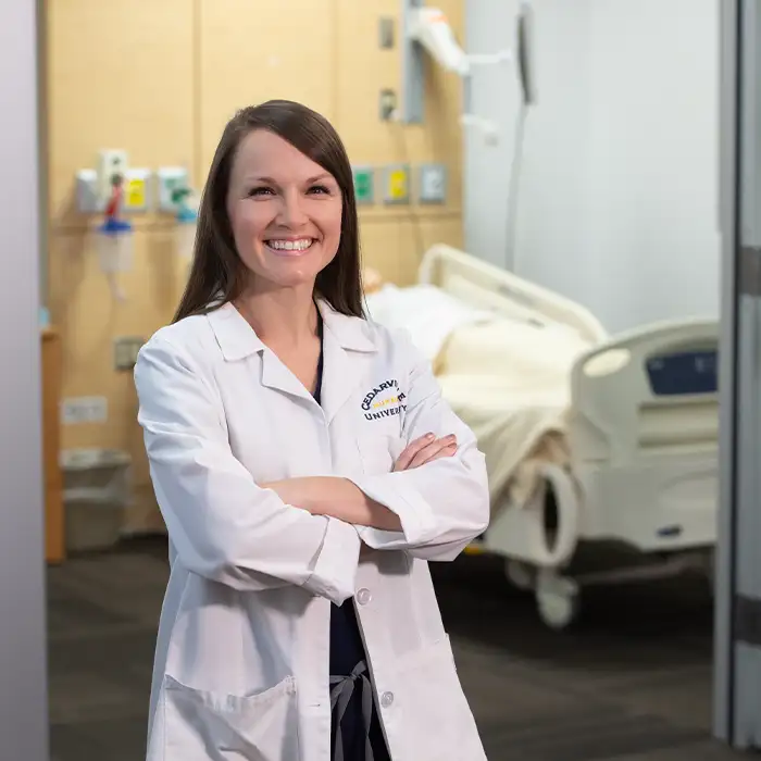 Amanda Minor, graduate nursing alumna of Cedarville University, stands in front of empty hospital bed