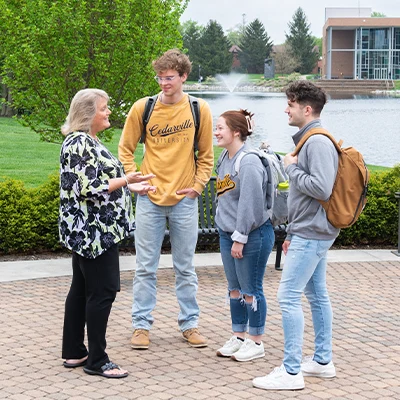 Professor talking with students outside.