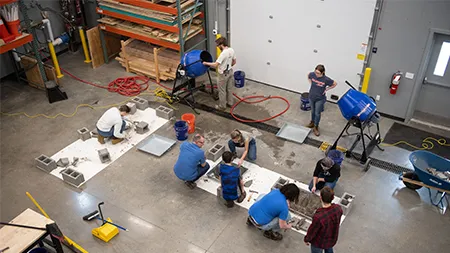 students working with professor for an engineering project