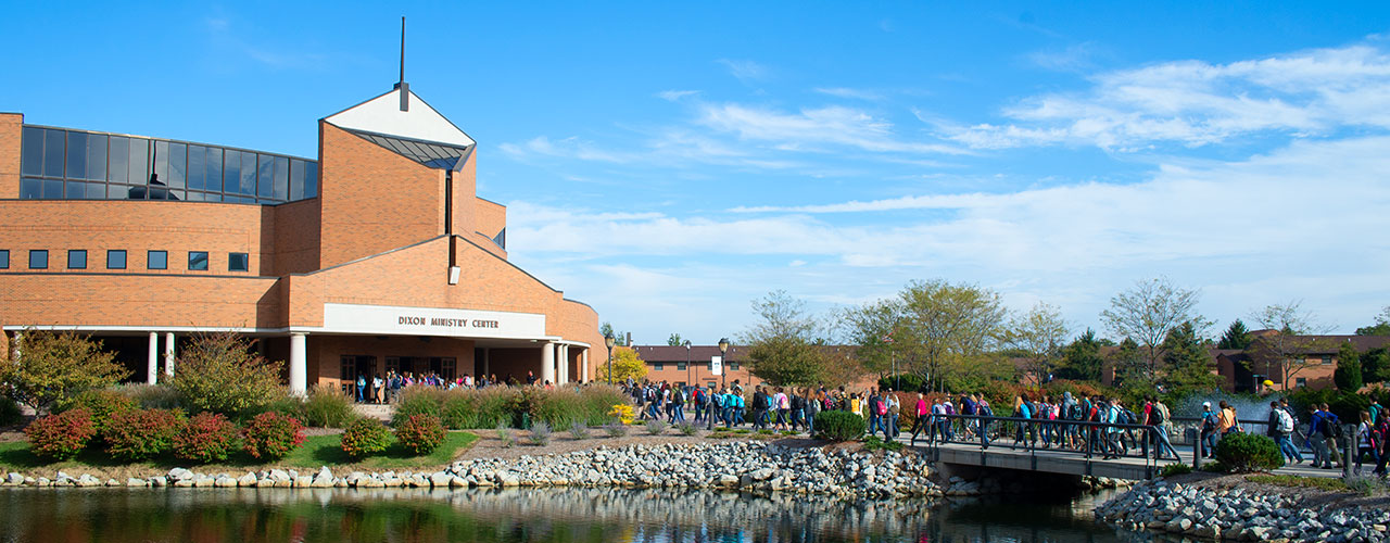 Photo of countless students entering the Dixon Ministry Center for Chapel with Cedar Lake in the foreground