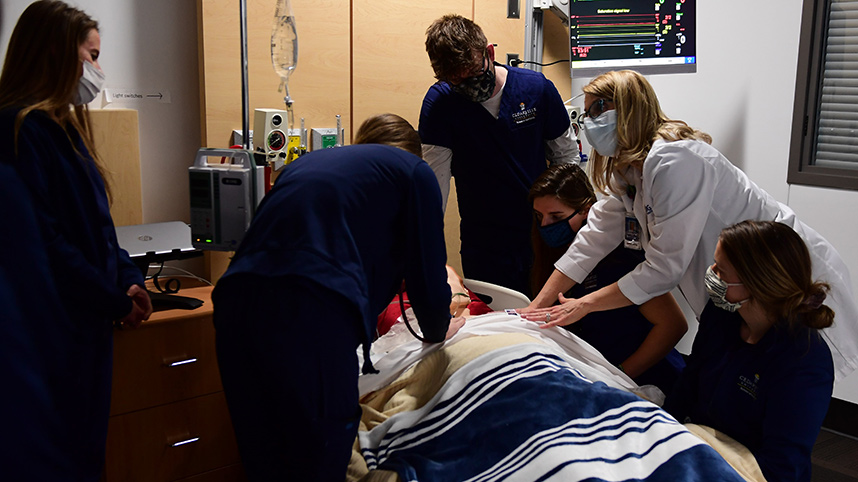 Dr. Beth Delaney leading a team exercise in the sim lab