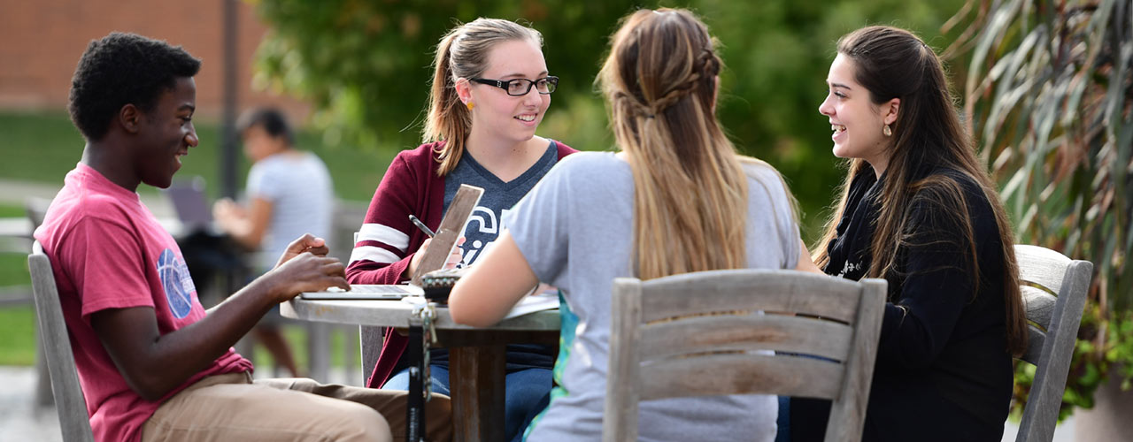 Students sit at table on campus at Cedarville