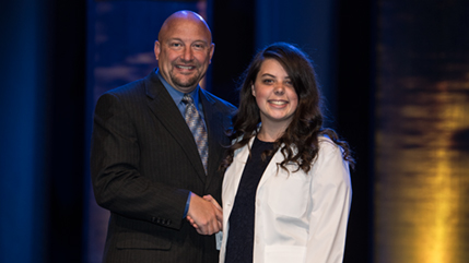 Student receives congratulations from Dr. Sweeney, dean of the School of Pharmacy