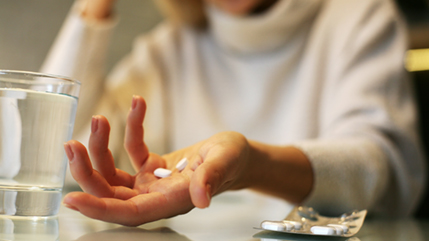 Woman holding prescription pills.
