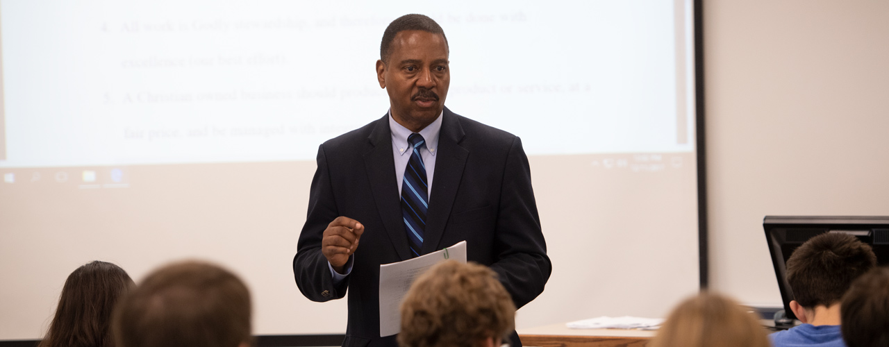 Dr. Patrick Oliver presenting in a classroom