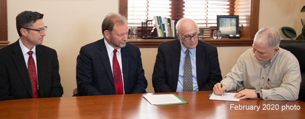 Dr. John Whitmore signing the agreement with the International Conference on Creationism