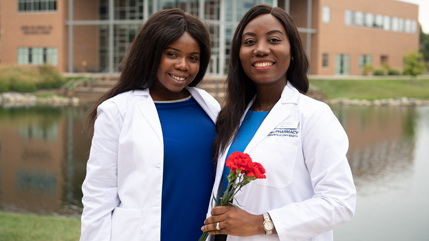 Current Cedarville University Pharmacy students Gloria Aboagye (left) and Abena Mpere (right) celebrate receiving their White Coats in 2019