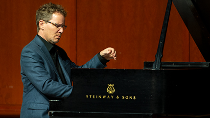 Dr. John Mortensen playing a Steinway piano.