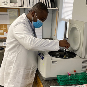 Dr. Kofi Amoah placing a blood sample in a centrifuge
