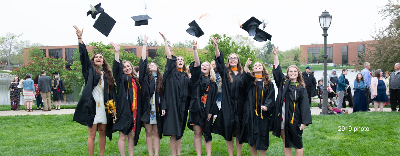 Graduates tossing mortar boards in the air after 2019 Commencement