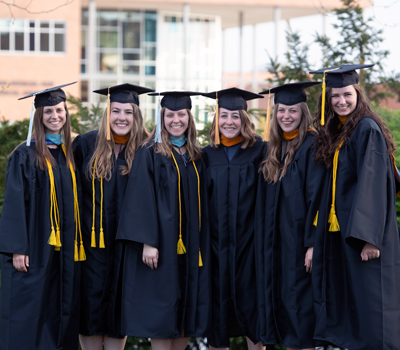A group of female graduates in front of the School of Biblical and Theological Studies