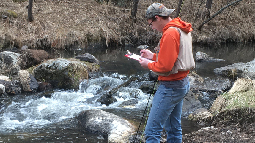 Carson Gehman records data about water quality from a local stream