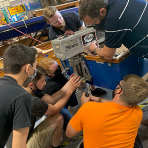 Engineering students work on a boat motor