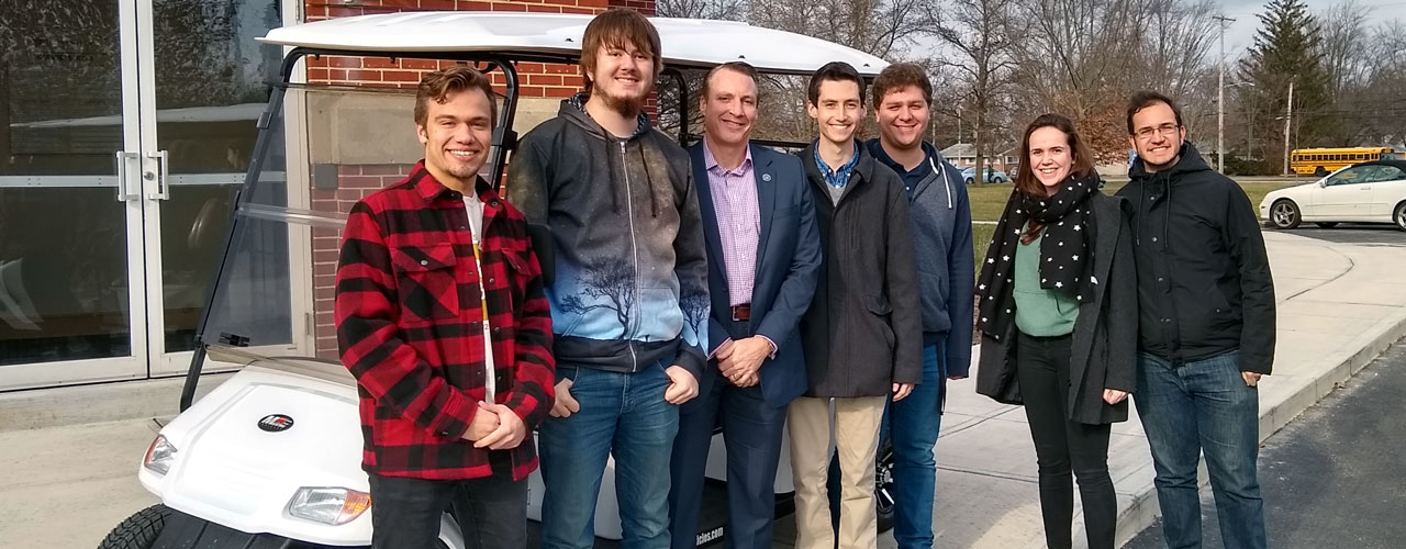 Left to right: Jake Lysack, Daniel Parker, Dr. White, Anson Allard, Joel Beckmeyer, Emma Burgess, Daniel Garcia pose in front of the new golf cart that Dr. White purchased for the autonomous vehicle project.