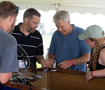 Dr. Gerry Brown and Dr. Tim Dewhurst working on the solar boat with two students