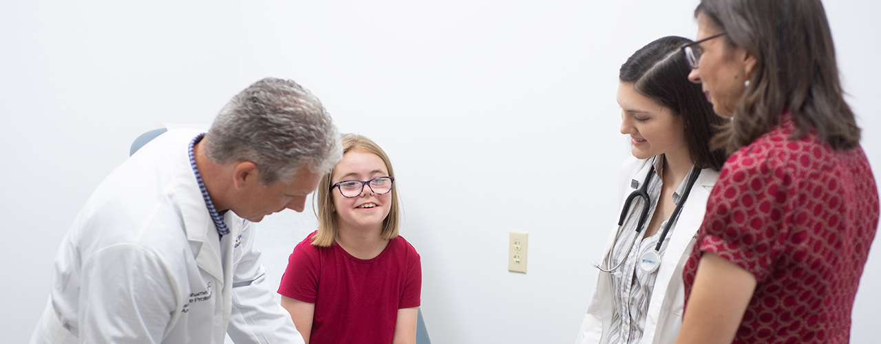 Jason Grahame, director of the PA program, a young patient, student Kyrie Baden, and medical director Dr. Misti Grimson