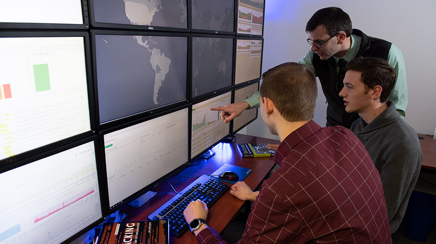 Professor Patrick Dudenhofer instructs students in the cyber lab