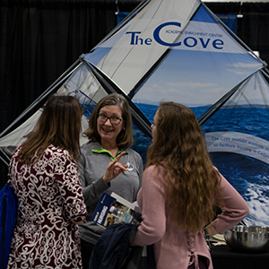 Cove staff member talking with students during a career fair