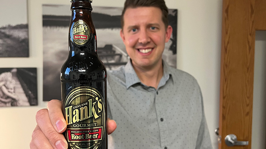 Matt Dearden holding up a bottle of Hank's Root Beer.
