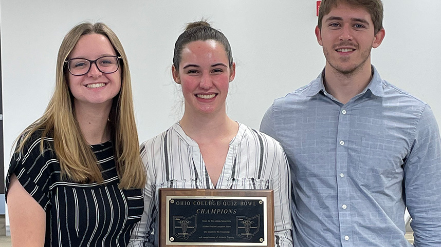 Cedarville's athletic training quiz bowl team members Kaitlyn Tyms, Claire Barker and Jacob Curran holding the tournament plaque.