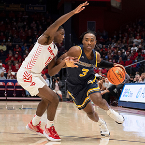 Tytist Dean drives the ball against a University of Dayton player in an exhibition game November 2021