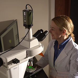 Dr. Heather Kuruvilla Looks at Samples in Microscope