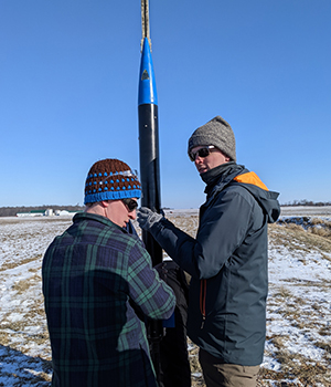 Mechanical engineering seniors Forrest Putnam and Chad Sanderson prepare the subscale rocket for launch