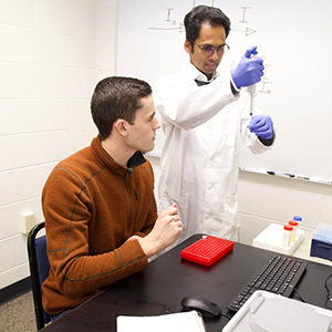 Dr. Mohan Pereira works with a student in the biophysics lab