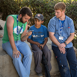 Two students talk about the Gospel with a little boy in Honduras