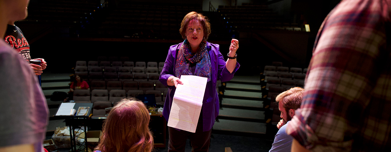 Dr. Diane Merchant speaks with students during a rehearsal.