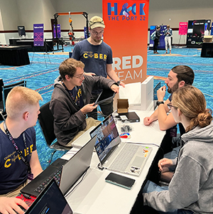 Cedarville senior computer science majors with a cyber operations specialization Aaron Campbell, Ryan Albrecht, Tim Dibert, Adam Marvin and Madeline Chairvolotti prepare to tackle a cyber challenge during Hack the Port ’22 in Fort Lauderdale, Florida.