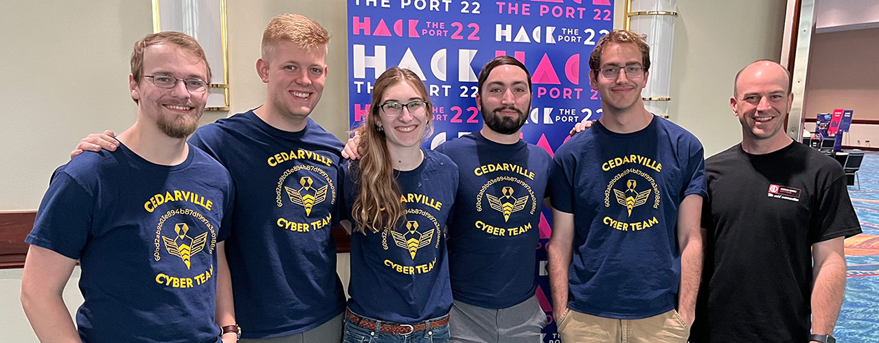 Cedarville senior computer science majors Tim Dibert, Aaron Campbell, Madeline Chairvolotti, Adam Marvin, Ryan Albrecht and associate professor of cyber operations and computer science, Dr. Seth Hamman, at Hack the Port ’22 in Fort Lauderdale, Florida.