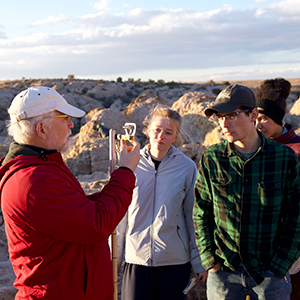 Dr. John Whitmore shows students a geology testing instrument