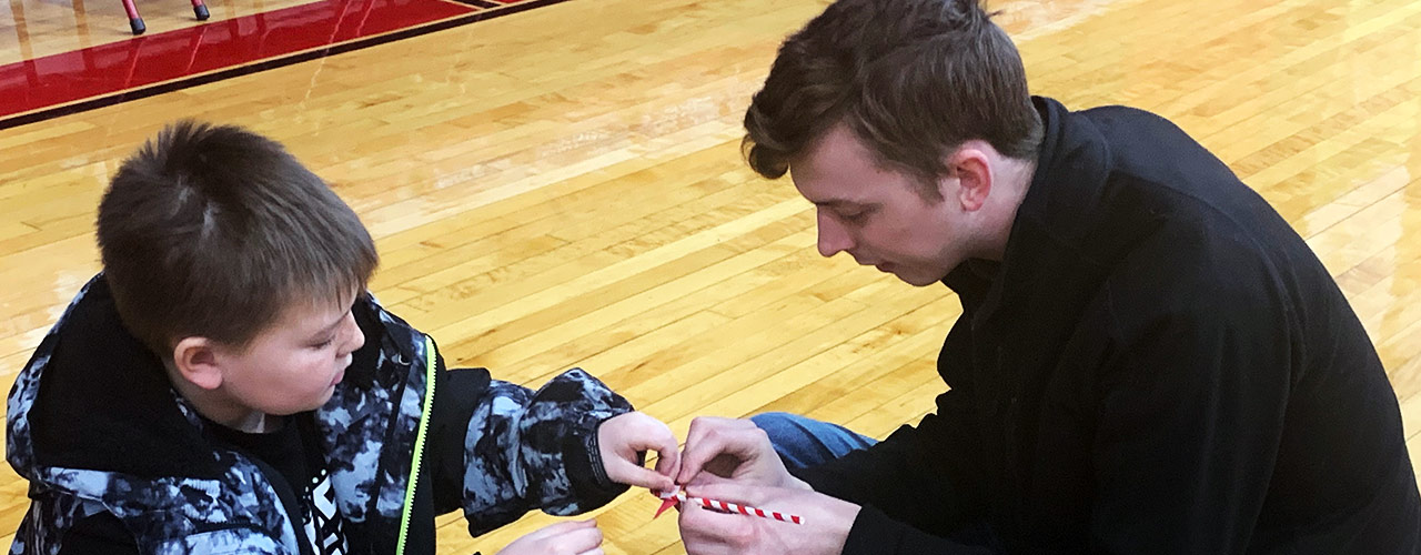 Cedarville University senior mechanical engineering student and NASA Student Launch team leader Chad Sanderson helps third grade students build straw rockets at Cedarville Elementary.