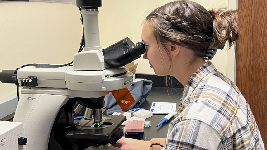 Tara Keller using a fluorescent microscope during her lab