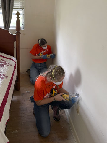 Students work in a damaged home.