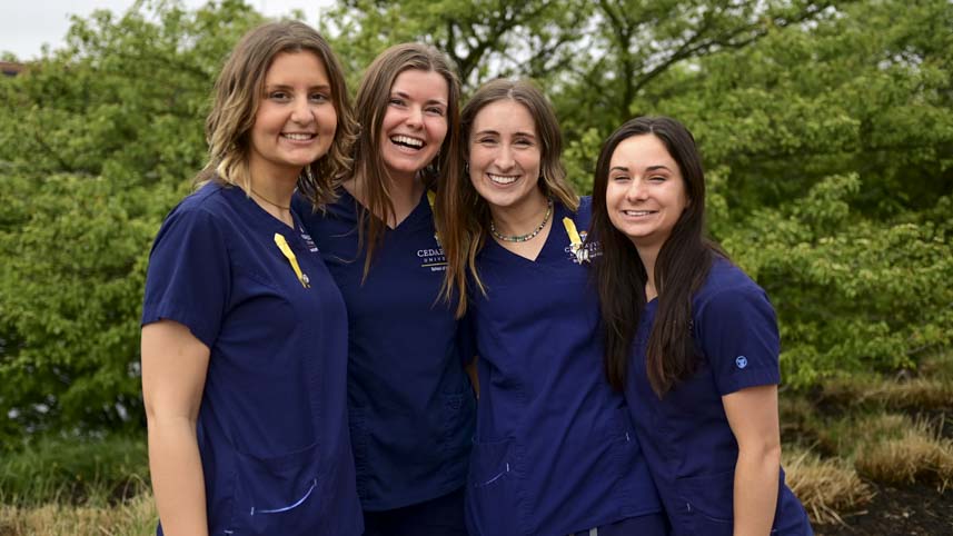 Four female nursing graduates posing after their pinning ceremony.