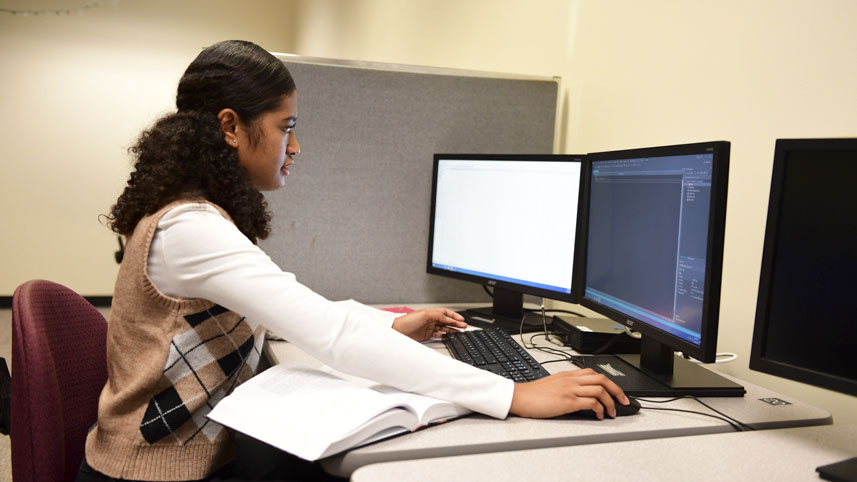 A computer science student practices her coding.