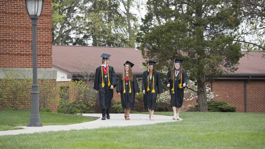 Oxford graduates walking on a sidewalk.
