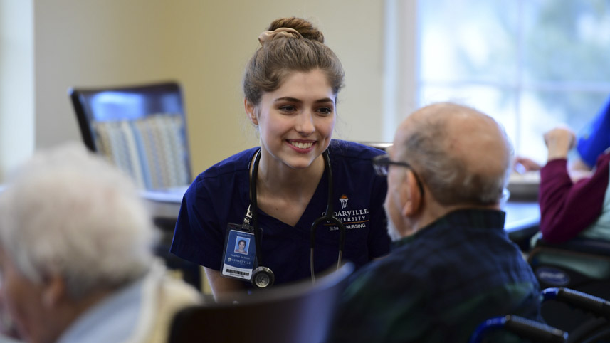 A Cedarville University nursing student interacts with an elderly man during clinicals.