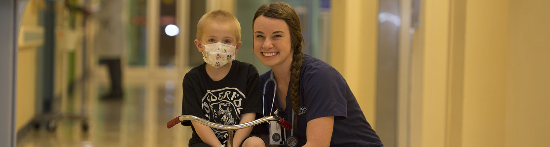 A Cedarville University nursing student encourages a young patient in a hospital.