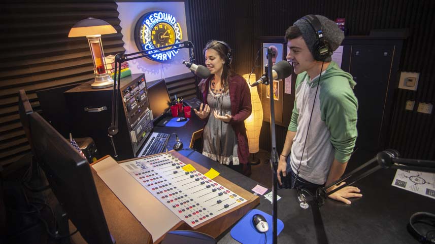 One male and one female student broadcast a resound radio show in studio.