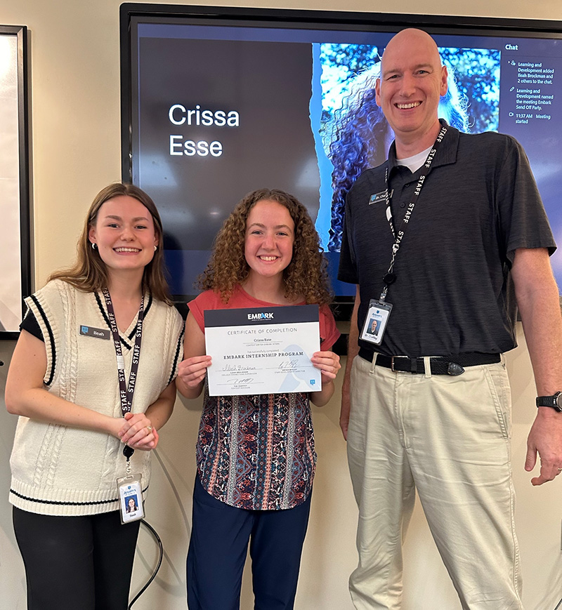 Crissa receiving her internship completion certificate with Dr. Tim Chaffey, Answers in Genesis' content manager and college conector supervisor, LLeah Brockman