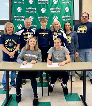 Julie and Ari Tompkins sign to run at Cedarville as their family look on.