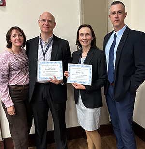 Dr. John Delano and Professor Alina Leo stand with their spouses after receiving a national award for their research on the ethical use of AI in higher education.